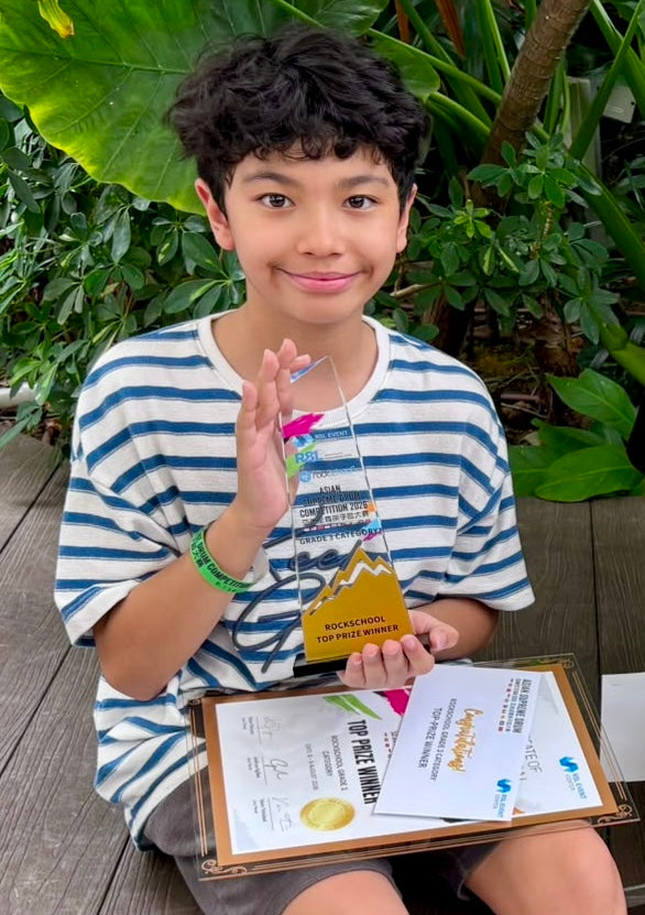 Damien Bernadelli holding Top Prize Winner trophy and certificate for Rockschool Grade 3 category at Asian Supreme Drum Competition ASDC 2026 Singapore